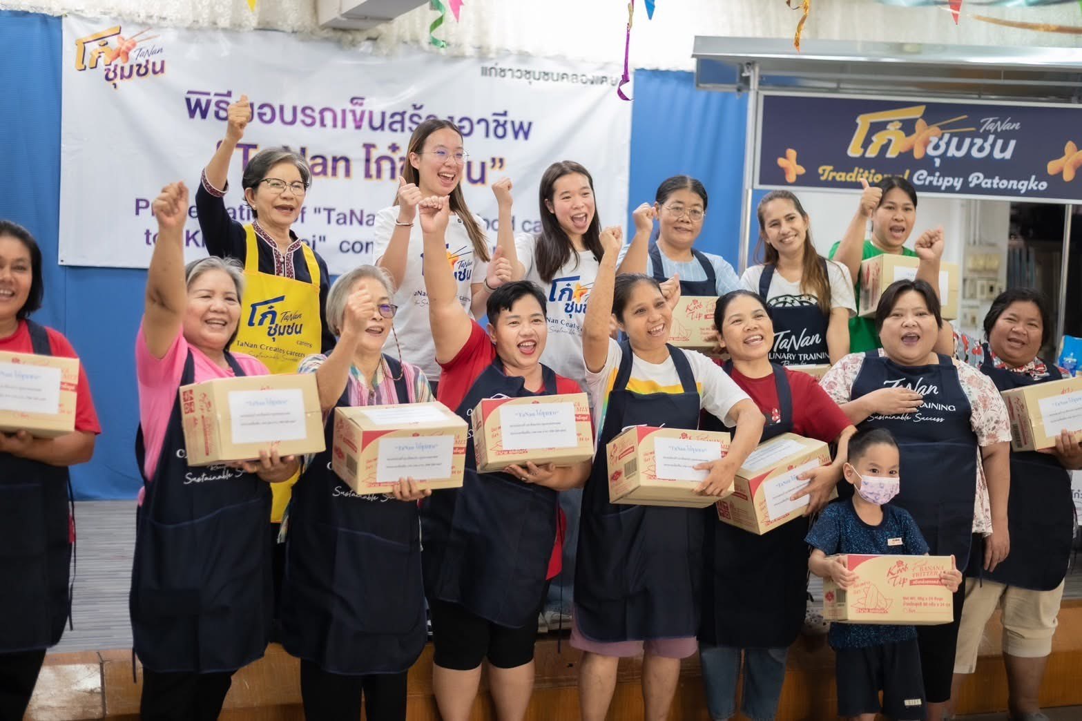Winnie celebrating with Klong Toei community members at the food cart handover